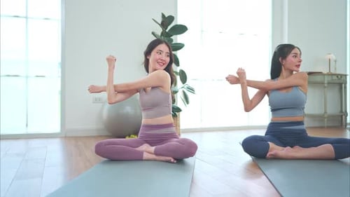 Women Exercise and Stretch on Yoga Mats
