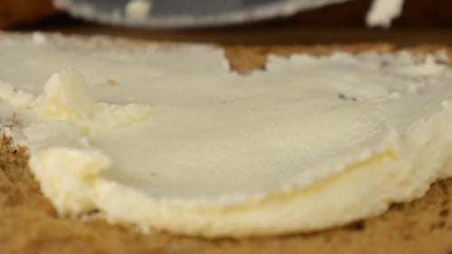 Spreading Rich Butter on Multigrain Bread Slice