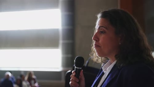 Woman speaking into microphone at a conference