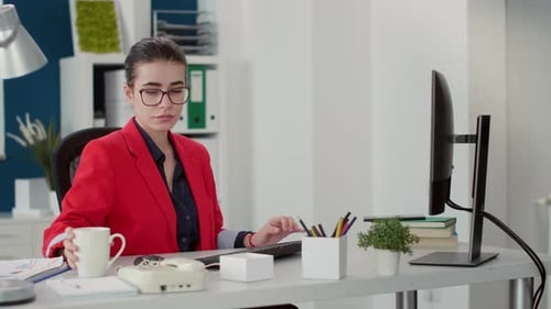 Young Woman Typing at Computer and Drinking Coffee