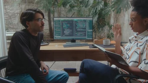 Female Programmer Explaining Computer Code to Colleague