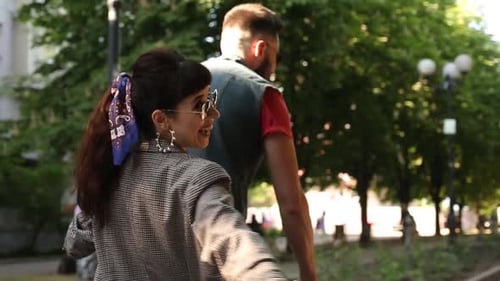 Vista traseira de uma mulher abraçando um homem se divertindo andando de bicicleta. Jovem casal andando de bicicleta juntos em