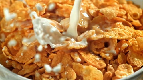 Milk Pouring into Bowl of Cornflakes for Breakfast