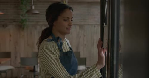 Employee Opening Cafe Restaurant, Turning Open Sign on Door