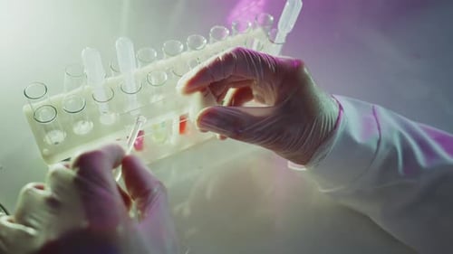 Scientist Analyzing Test Tubes with Colorful Liquids in Laboratory