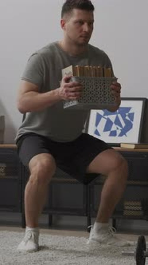 Homme organisant l'espace du salon tout en tenant un panier de rangement près d'une armoire moderne et abstraite