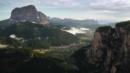 Beautiful mountain aerial view of Dolomite Alps and a small town during sunset