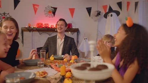 Family Enjoys Halloween Celebration Around Dinner Table