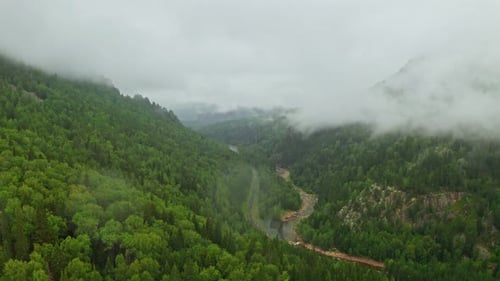 Ethereal Clouds Gliding Over a Serene Mountain Valley
