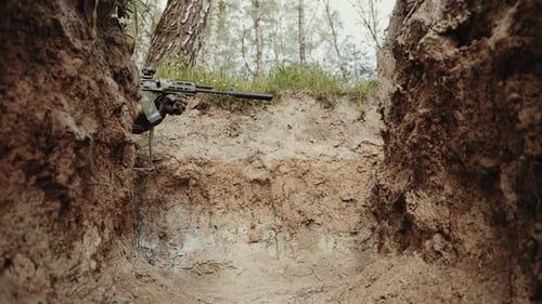 Military Sniper in Concealment Soldier in Sniper Camouflage Aiming a Rifle in a Dugout