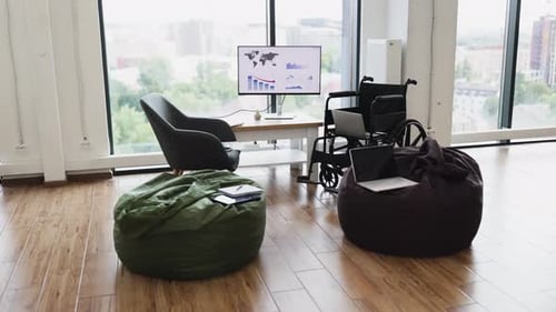 Modern Office with Wheelchair and Graph on Screen