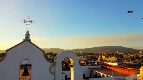 Sunset sunrise in temple church pigeons flying in summer in a traditional town in jalisco with hill