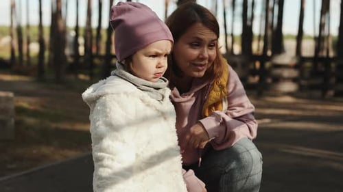 Mother and Her Little Daughter Happily Enjoying the Beauty of Nature in the Autumn Park Chatting in