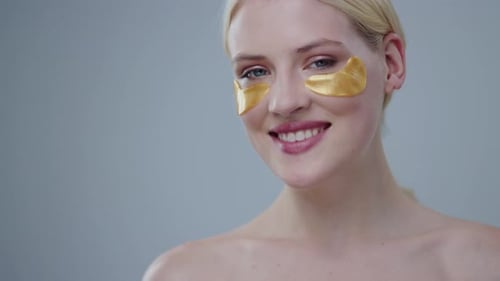 Blonde Woman with Gold Patches Smiling at Camera