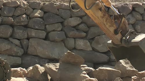 Backhoe Loading and Moving Rocks