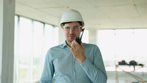 Ingenieur leitet den Bau mit Radio und Laptop