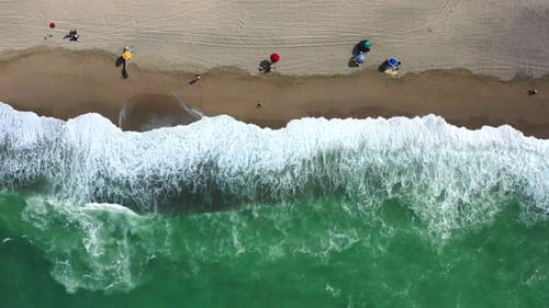 Wavy Sea And Sunbeds On The Beach