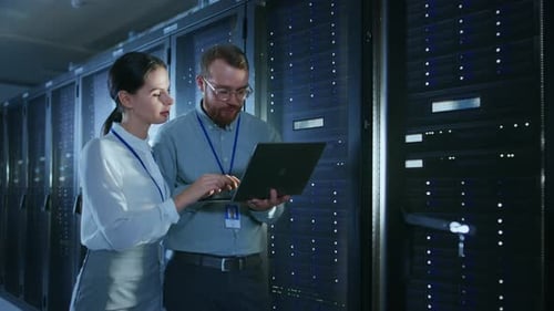 Bärtiger IT-Techniker mit Brille und Laptop, schöne junge Ingenieurkollegin Are Talki