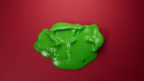 Grüner Schleim, der auf roter Oberfläche schmilzt