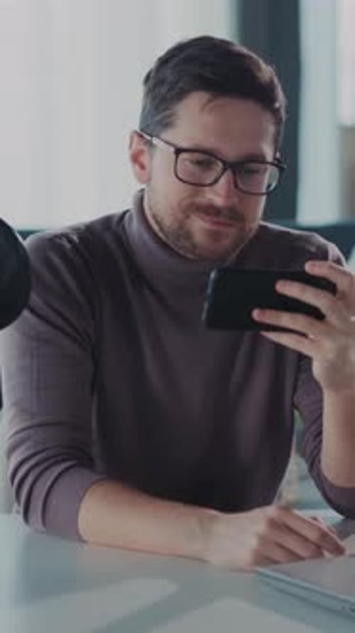 Man Using Smartphone Indoors at Desk