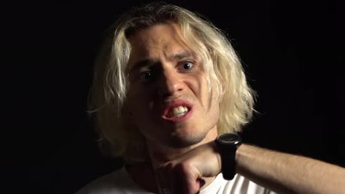 Young Adult Makes Aggressive Gestures in Dark Room