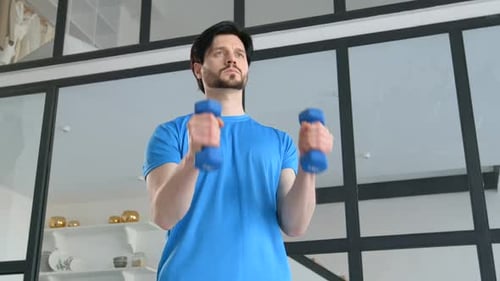 Man Lifting Dumbbells Indoors for Fitness Training