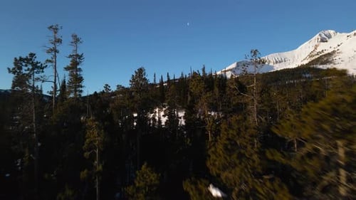 A drone shot of snowy Big Sky, Montana in winter, showcasing the ski resort and majestic mountain te