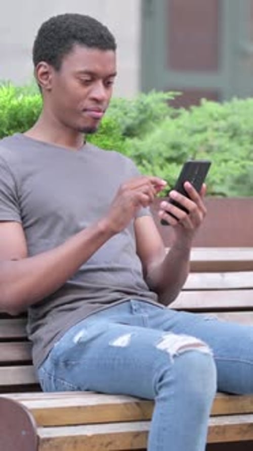 Excited Man Receives Good News on Smartphone Outside