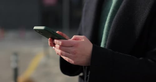Woman Hands Using Smartphone Outdoors on City Searching or Social Networks Concept