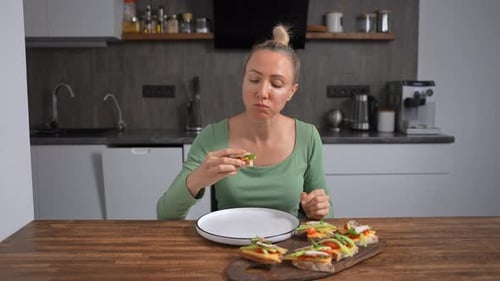 Woman Enjoying Healthy Open-Faced Sandwiches in Kitchen