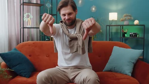 Upset Caucasian Man Showing Thumbs Down Dislike Bad Work Disapproval Dissatisfied Feedback at Home