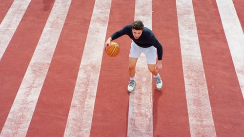 Un homme dribble un ballon de basket dans le parc