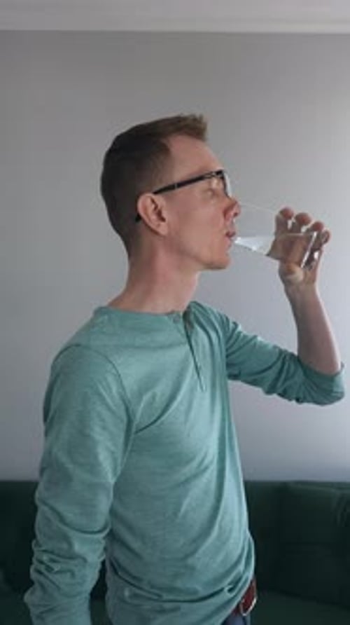 Man Takes a Pill and Drinks Water
