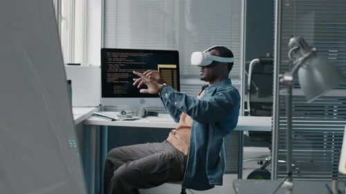 Black Man Wearing VR Headset while Working in Office