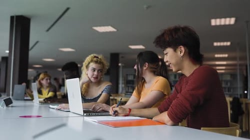 Young diverse people studying in library - School education concept