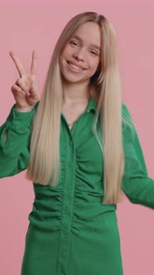 Smiling Woman Showing Peace Sign in Studio Setting