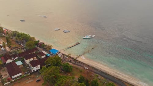 Aerial view of tranquil village by the sea at sunrise, Indonesia.