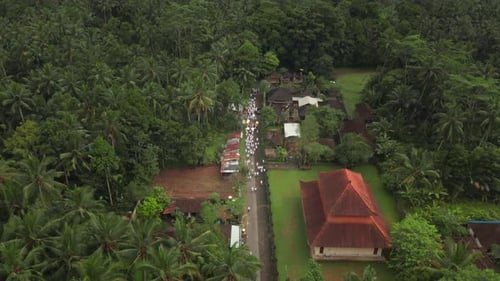 Défilé hindou traditionnel en vêtements blancs dans une rue rurale de la région tropicale de Bali, vol aérien