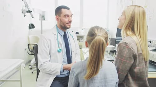 Low Angle Shot of Friendly Doctor Explaining How Medicine Works to a Cute Little Girl and Her Mothe