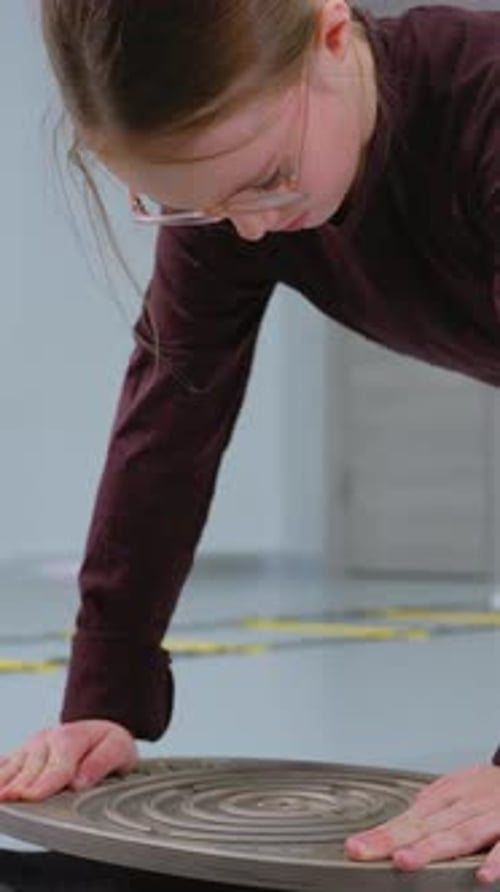 Girl Working to Balance Ball Through Maze