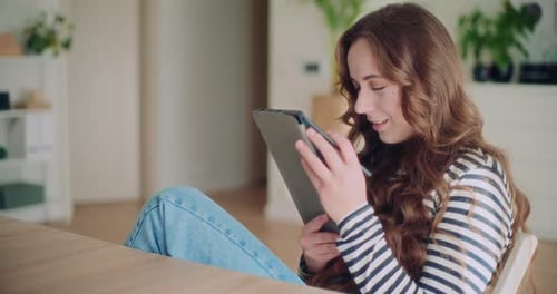 Young Woman Uses Tablet and Stylus at Desk