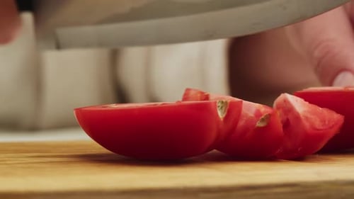 Knife Slicing Fresh Tomato on Wooden Board