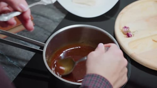 Person Making Caramel Sauce in Kitchen at Home