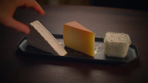 Close Up of Cheese Tray with Hand Reaching