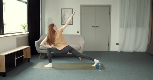 Jolie dame en leggings et haut faisant de l'exercice à la maison