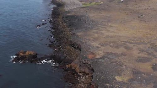 Wild coast of Iceland with solid lava field with water from Atlantic Ocean
