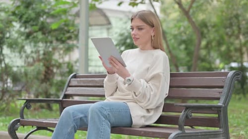 Woman Using Tablet on Park Bench