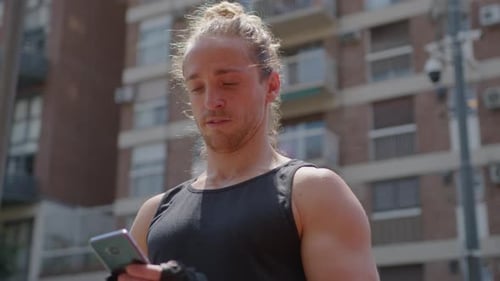 Young Adult Using Phone After Workout in City