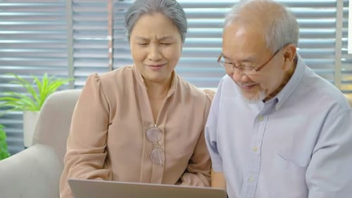 Happy Senior Couple Using Laptop Together at Home