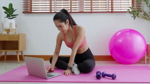 Woman Uses Laptop on Exercise Mat at Home